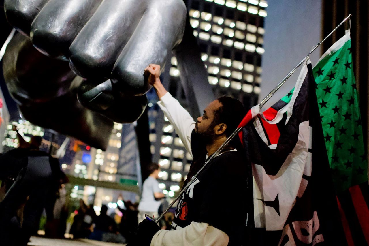 Franklin Long touches a monument to boxer Joe Louis in downtown Detroit as protesters march calling for justice for Taylor.