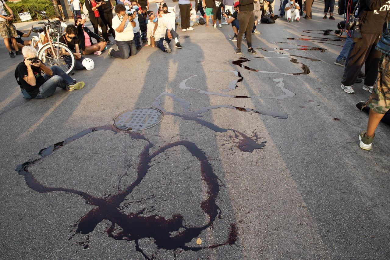 Father Michael Pfleger led a group of protesters in Chicago before using fake blood to paint Taylor's name on the street.