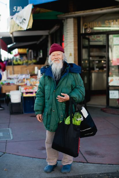Retired butcher Sidney Yuen walks home with his groceries in Oakland's Chinatown.