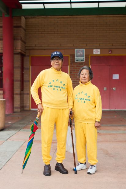 A married couple, the Jungs, pictured in bright yellow sweatsuits that were custom-made in Hong Kong.