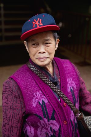 Retired gardener Gui Zhi Li wears a purple orchid vest and baseball cap in Manhattan's Chinatown. 