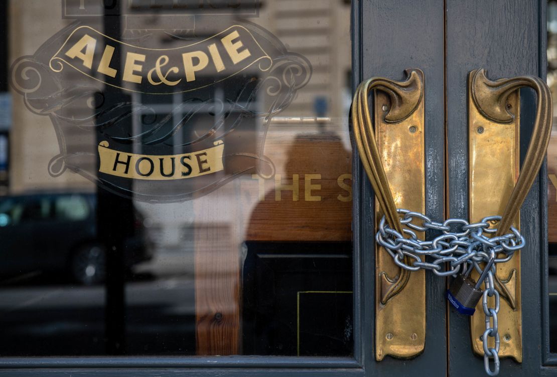 A lock and chain is in place across the entrance to a closed pub in London in June.