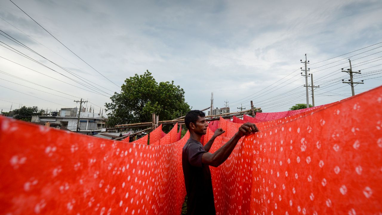 TOPSHOT - A worker dries fabric after dyeing them at a factory in Narsingdi, some 50 km from Dhaka, on July 4, 2020. (Photo by MUNIR UZ ZAMAN / AFP) (Photo by MUNIR UZ ZAMAN/AFP via Getty Images)
