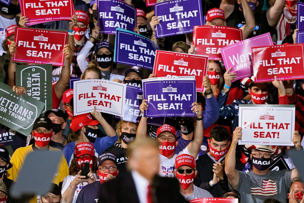 Trump supporters hold up signs as he speaks at a campaign rally in Swanton, Ohio, on September 21.