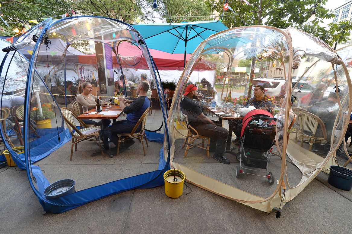 People eat inside plastic pop-up "space bubble" tents in front of Cafe Du Soleil in Manhattan on Tuesday, September 22.