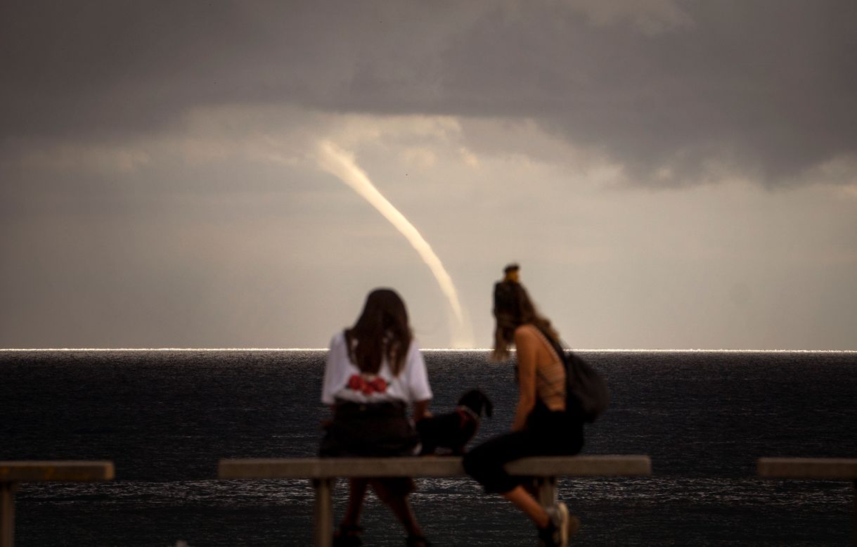 People watch a funnel cloud form in Barcelona, Spain, on Monday, September 21. 