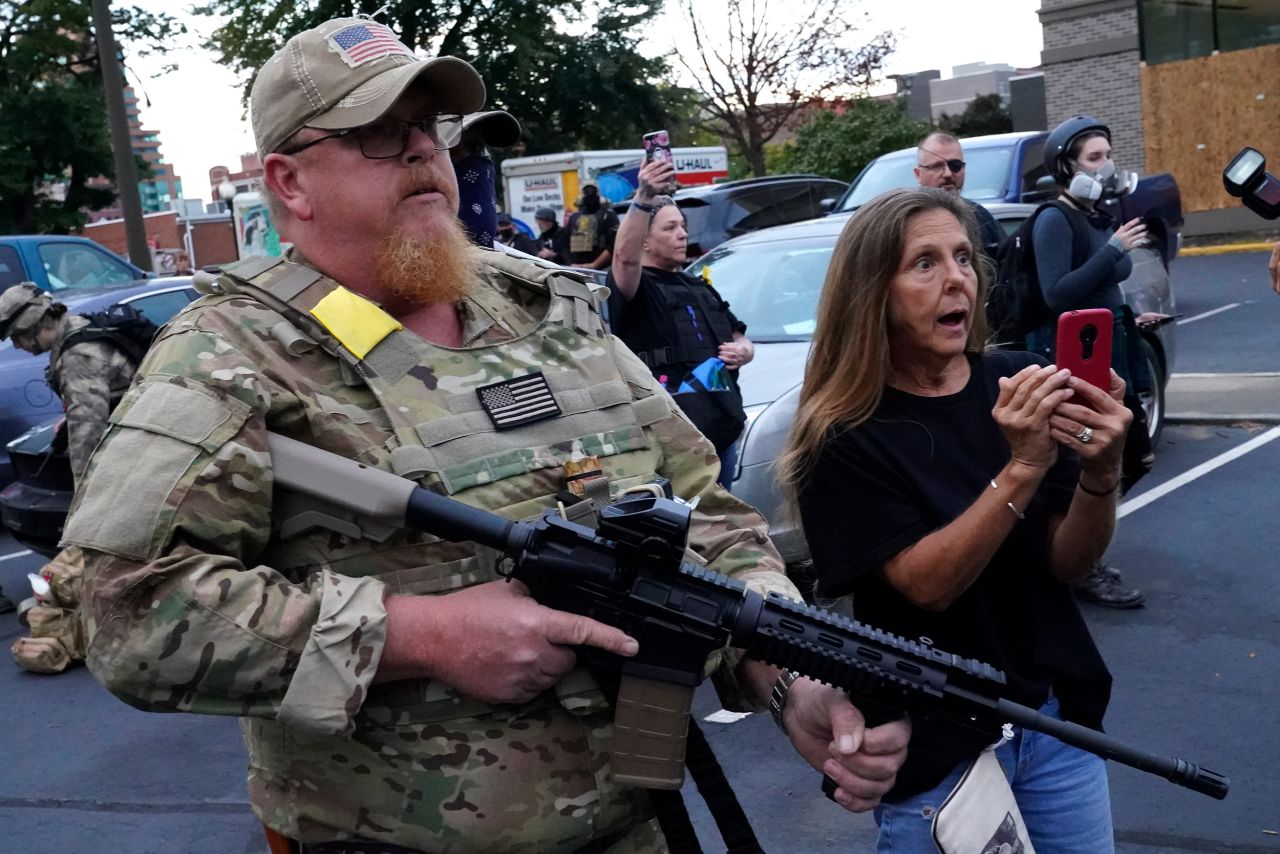 An armed counterprotester speaks with Black Lives Matter demonstrators on September 24 in Louisville, Kentucky.