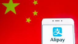 HONG KONG - 2019/04/06: In this photo illustration a Chinese online payment platform owned by Alibaba Group, Alipay, logo is seen on an Android mobile device with People's Republic of China flag in the background. (Photo Illustration by Budrul Chukrut/SOPA Images/LightRocket via Getty Images)