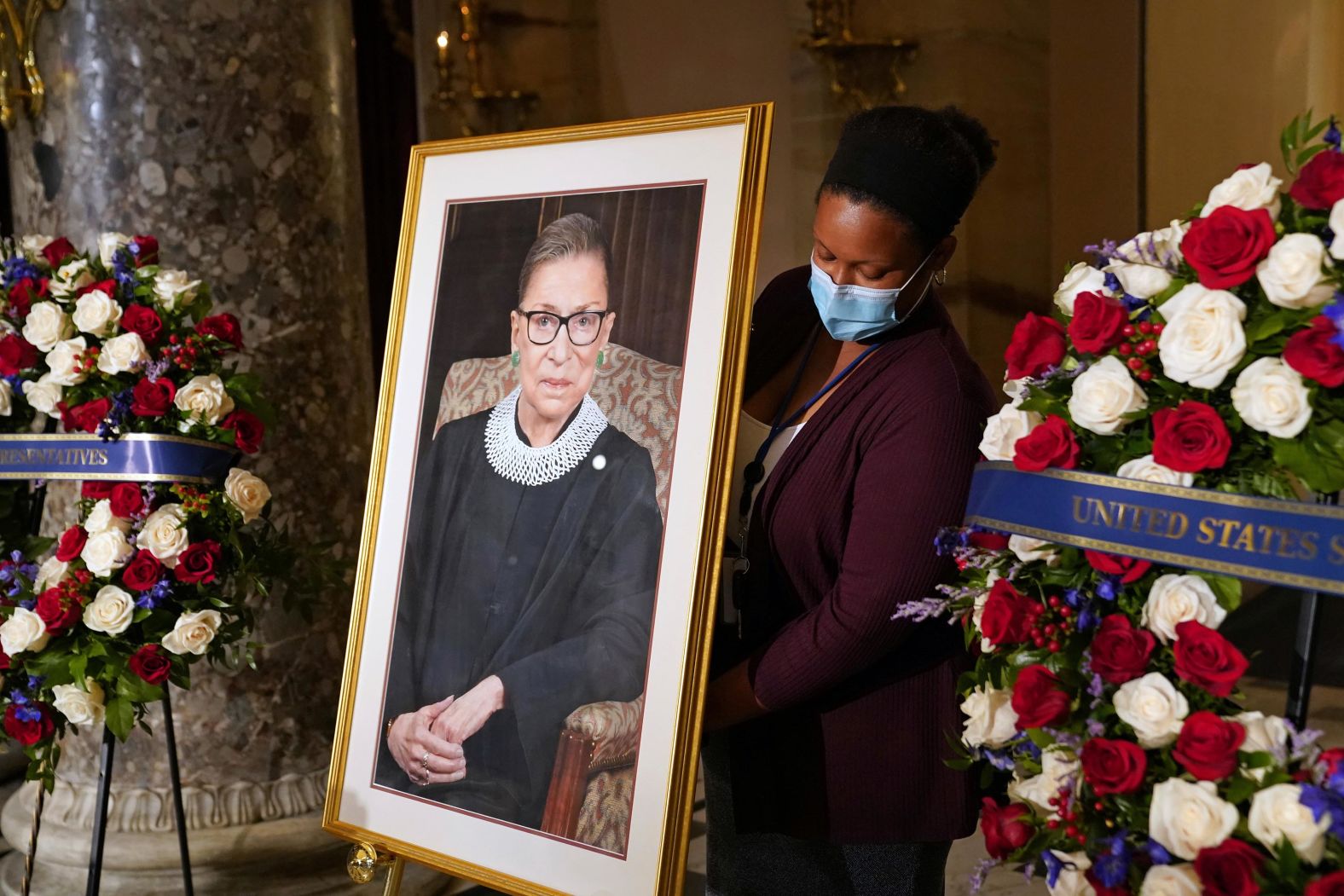 A staff member places a portrait of Ginsburg before the ceremony at the US Capitol.