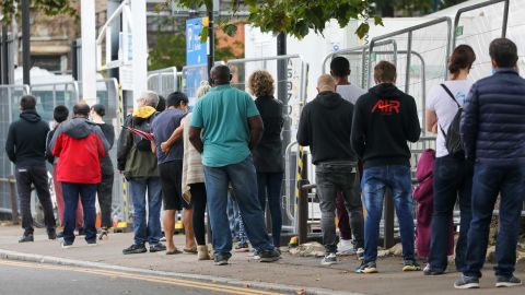 Visitors stand in line at a coronavirus walk-in testing center in Edmonton, London, on Wednesday.