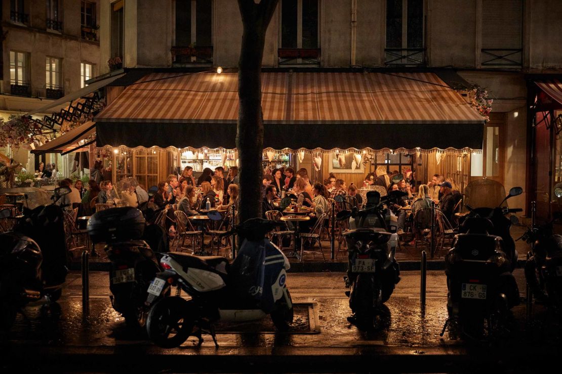 Customers crowd a Parisian cafe Wednesday as the French government announced that from Monday all bars in the city will shut at 10 p.m.