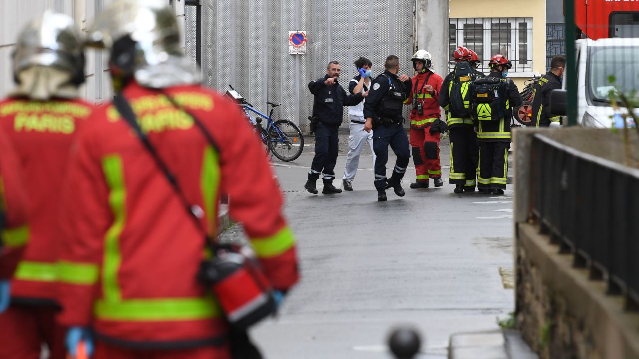 French firefighters move an injured person into an ambulance near the former offices of the French satirical magazine Charlie Hebdo.