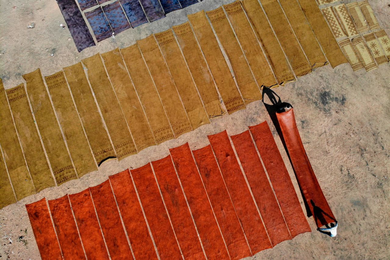Artisans lie fabrics on the ground to dry after undergoing a synthetic indigo dye process in Bagru village, near India's Jaipur in December 2019.