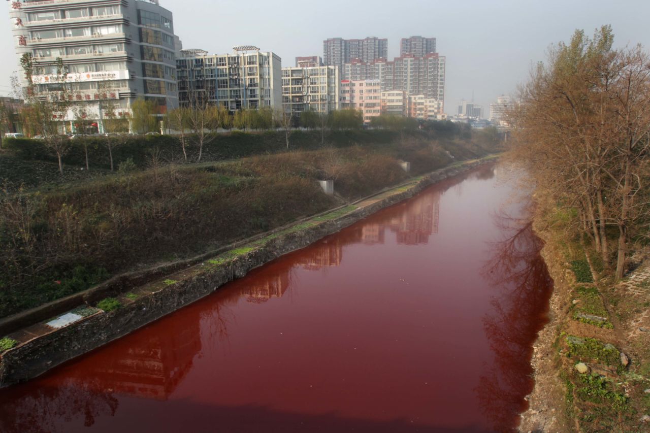 The polluted Jian River in Luoyang, north China's Henan province, runs red from the dye that was dumped into the city's storm water pipe network in December 2011. 