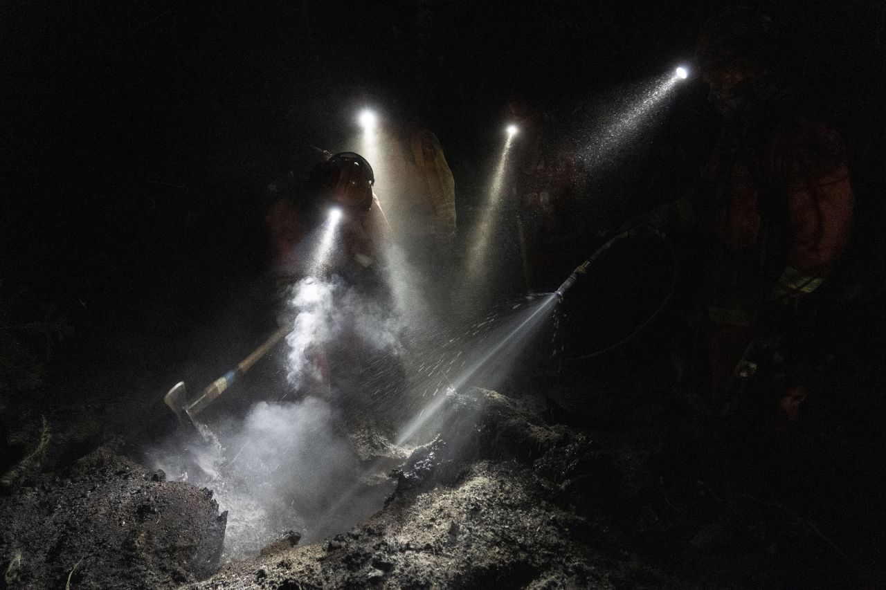 Inmate firefighters extinguish hot spots while working to contain the Bear Fire on September 24.