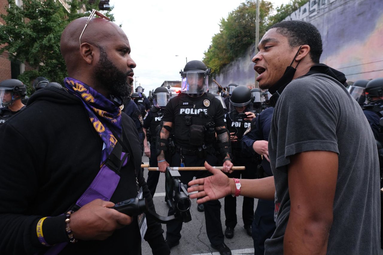 A demonstrator speaks in front of a police line in Louisville on September 25.