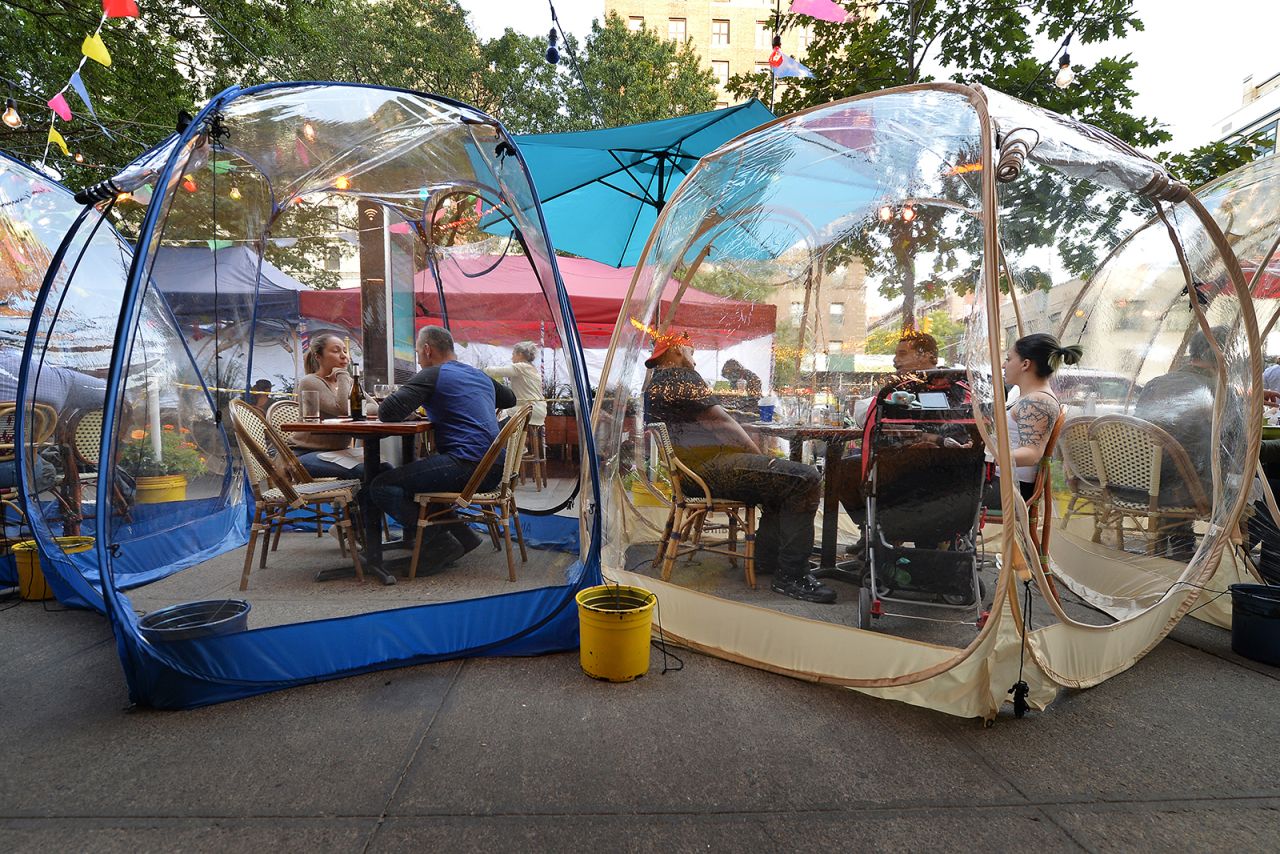 People eat inside plastic pop-up "space bubble" tents in front of New York's Café Du Soleil on September 22.
