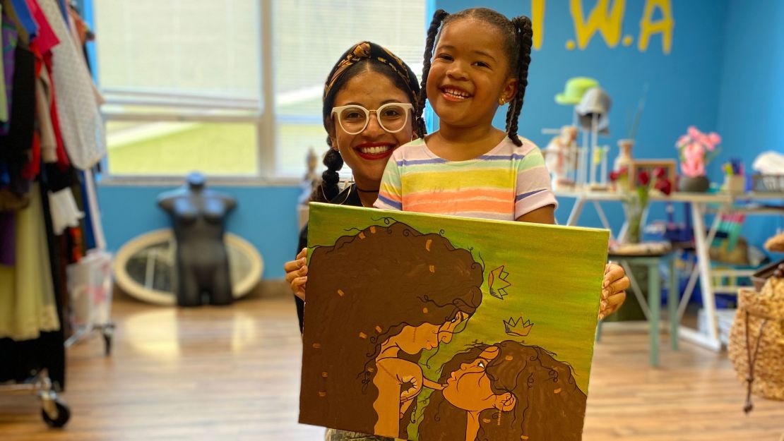 Ashlee Phillips poses in her Louisville, Kentucky, thrift store with her daughter Braylee.