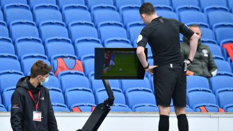 Referee Chris Kavanagh checks the VAR screen during the match between Brighton and Manchester United. 