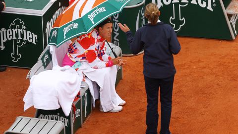 Victoria Azarenka talks with a match supervisor during a pause in her first-round match at the 2020 French Open.