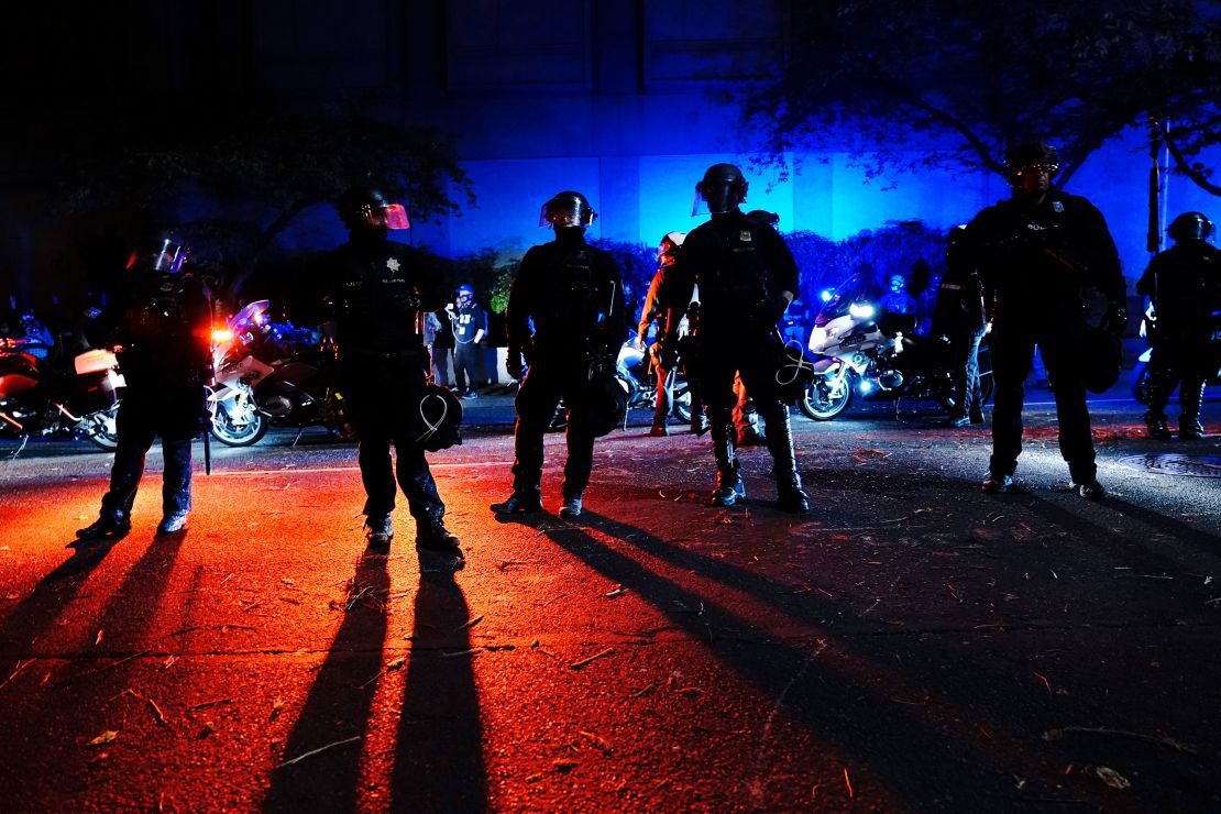 Police stand in a street during Saturday night's protests in Portland. 