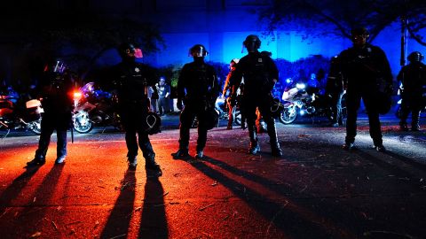 Police stand in a street during Saturday night's protests in Portland.