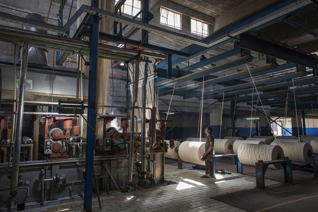 A denim dyeing plant in Karachi, Pakistan shows spools of cotton before they are colored blue.