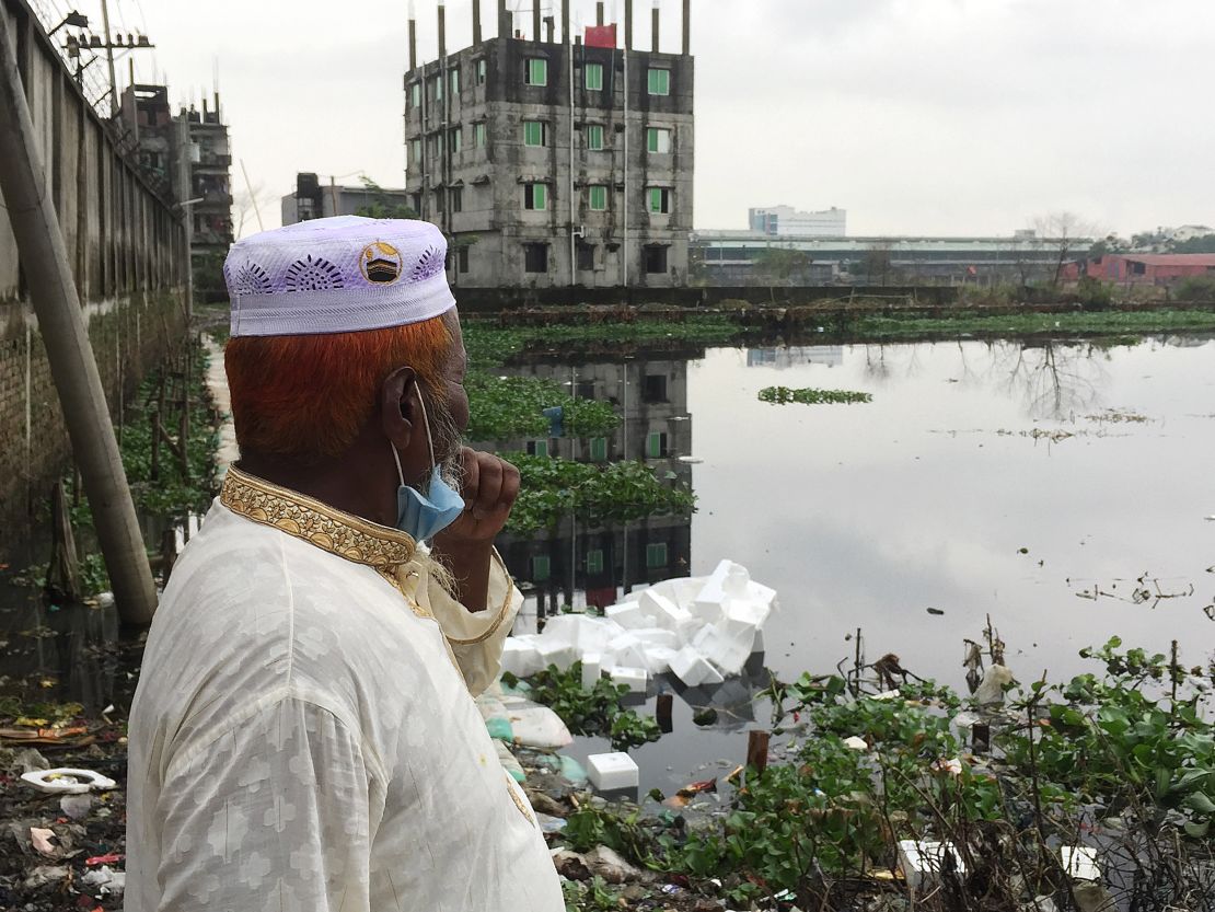 Haji Muhammad Abdus Salam, looks out over a polluted canal near his home that connects to the Dhaleshwari River in Savar, Bangladesh.