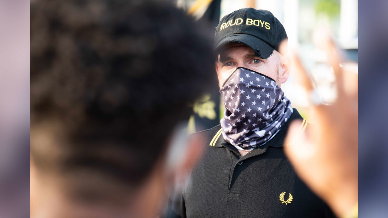 A man wearing a Proud Boys hat and a scarf bearing the American flag faces off with protestors at a "Back the Blue" event in Philadelphia on July 9, 2020.