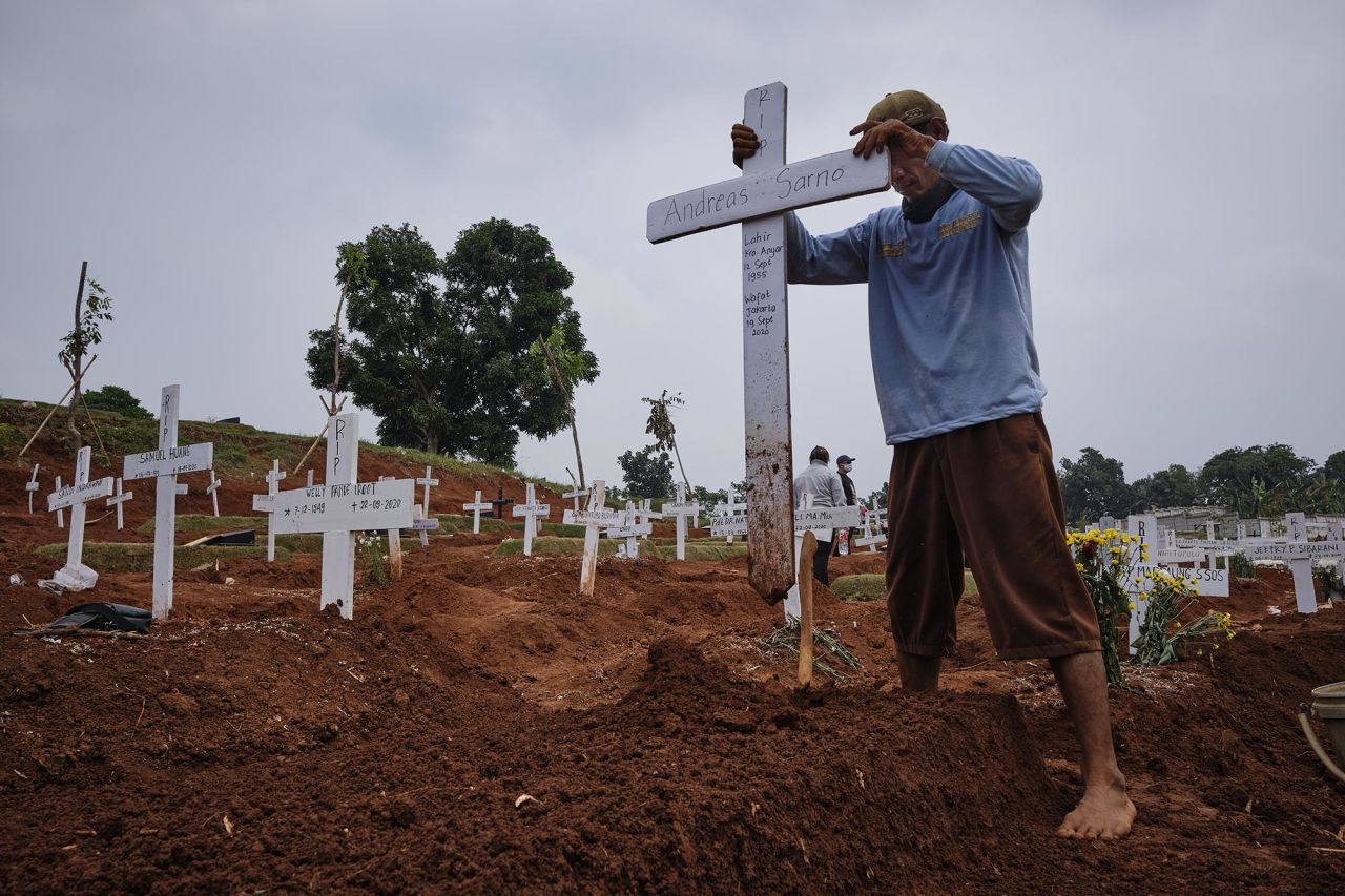 A grave digger in Jakarta, Indonesia, plants a cross in a public cemetery, part of which is reserved for suspected Covid-19 victims, on September 26.