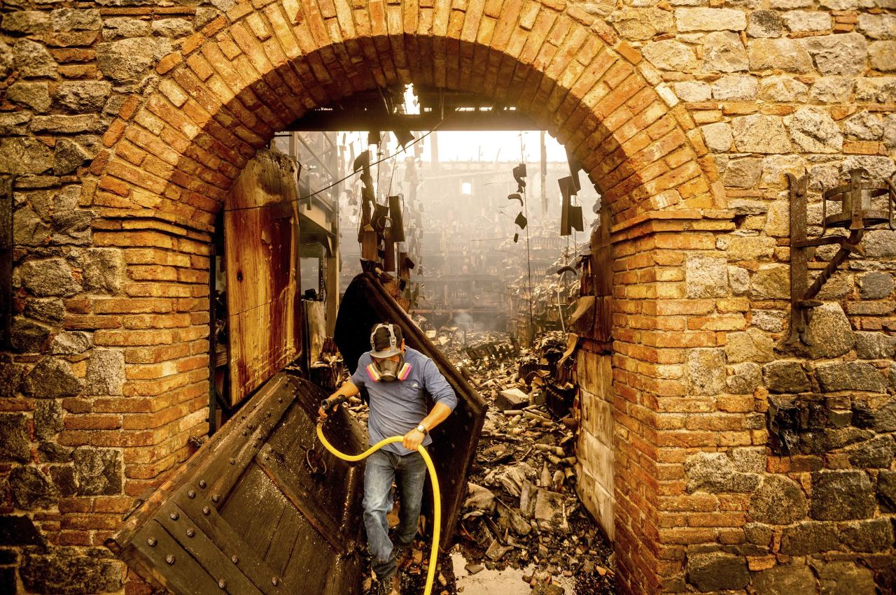 Cellar worker Jose Juan Perez extinguishes hotspots at Castello di Amorosa, a Calistoga winery that was damaged in the Glass Fire.