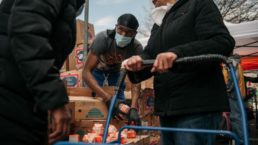 A worker distributes orange juice at a food shelf organized by The Campaign Against Hunger in Bed Stuy, Brooklyn on April 14, 2020 in New York City. Food insecurity is one of many economic threats posed by the ongoing coronavirus crisis, which has shuttered nonessential businesses and caused unemployment claims to rise dramatically.