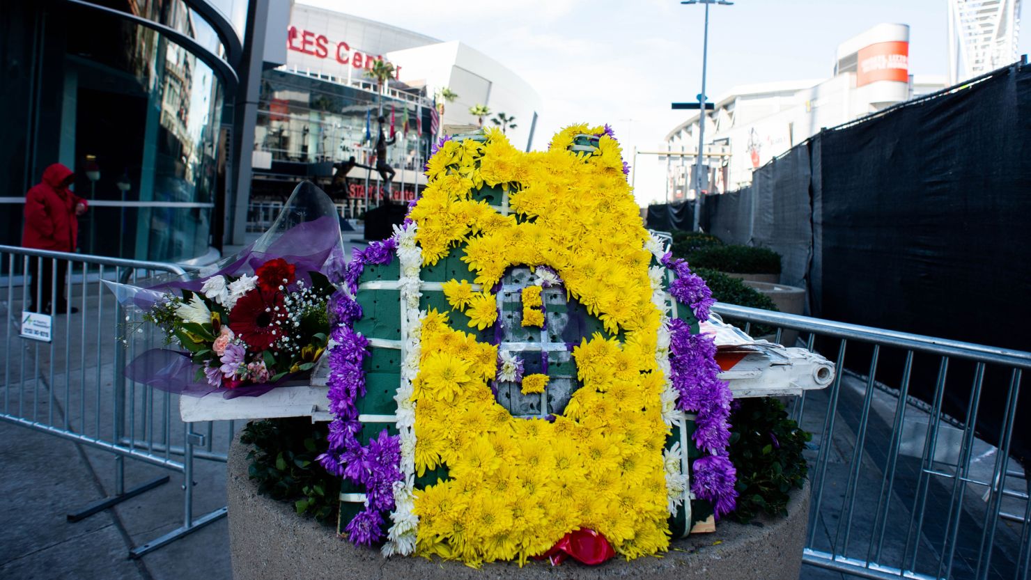 Crews behind a screened fence remove Kobe Bryant's memorial at L.A. Live on Monday, February 3, 2020 as a few scattered items are left around Staples Center.