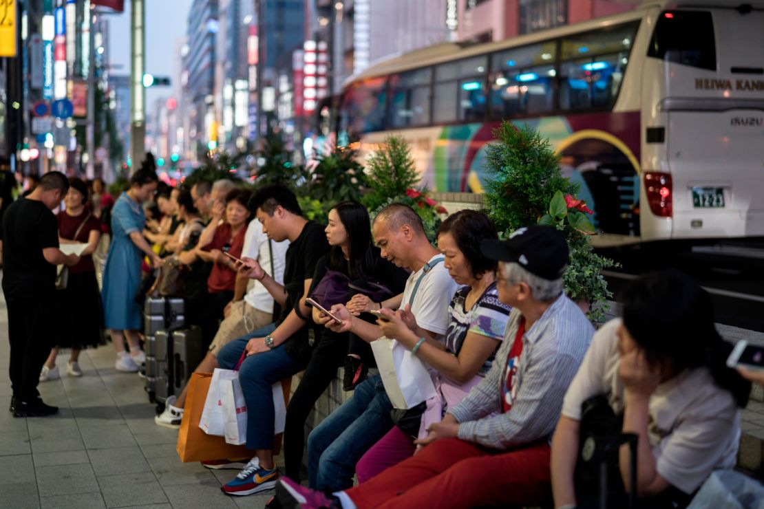 Chinese tourists wait for their tour bus in the Ginza shopping district on October 02, 2019 in Tokyo, Japan. 