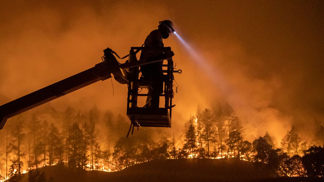 The Glass Fire burns as Josh Asbury, an employee of CableCom, installs fiber optic cable in Calistoga, California, on September 28, 2020.