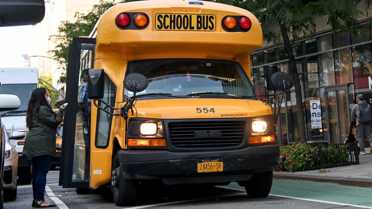 NEW YORK, NEW YORK - SEPTEMBER 22: A worker waits for students as they as they get off a school bus as the city continues Phase 4 of re-opening following restrictions imposed to slow the spread of coronavirus on September 22, 2020 in New York City. The fourth phase allows outdoor arts and entertainment, sporting events without fans and media production. (Photo by Alexi Rosenfeld/Getty Images)