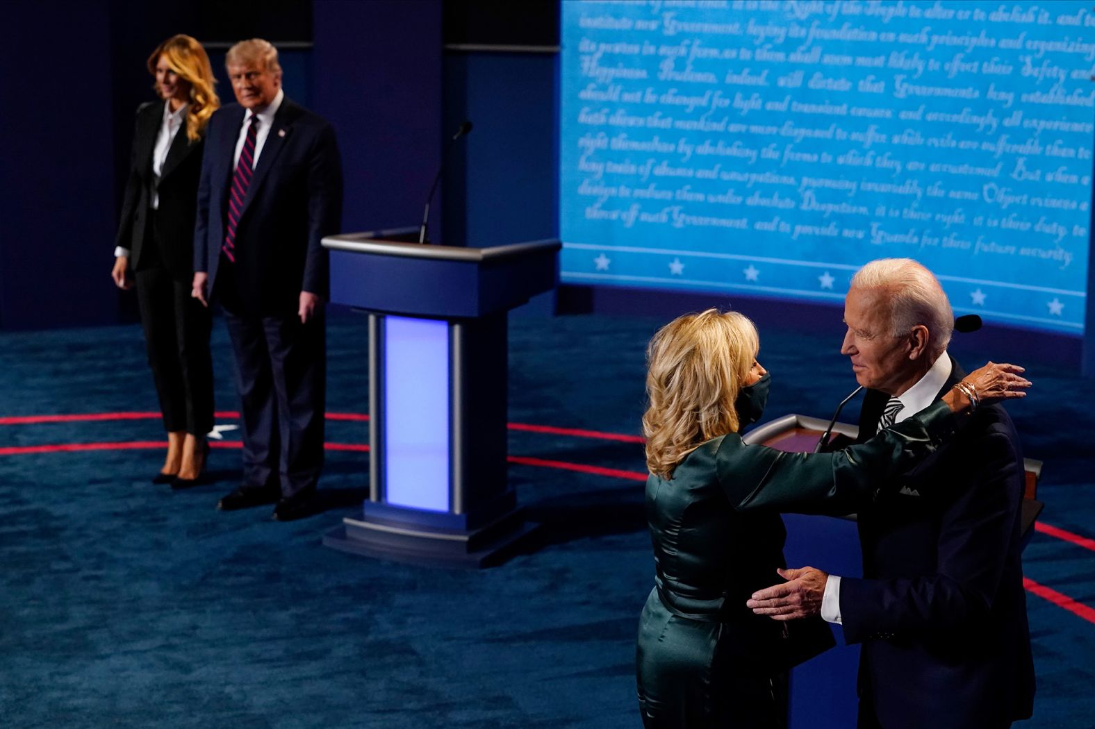 Biden is hugged by his wife, Jill, at the end of the debate while Trump is joined by his wife, Melania.