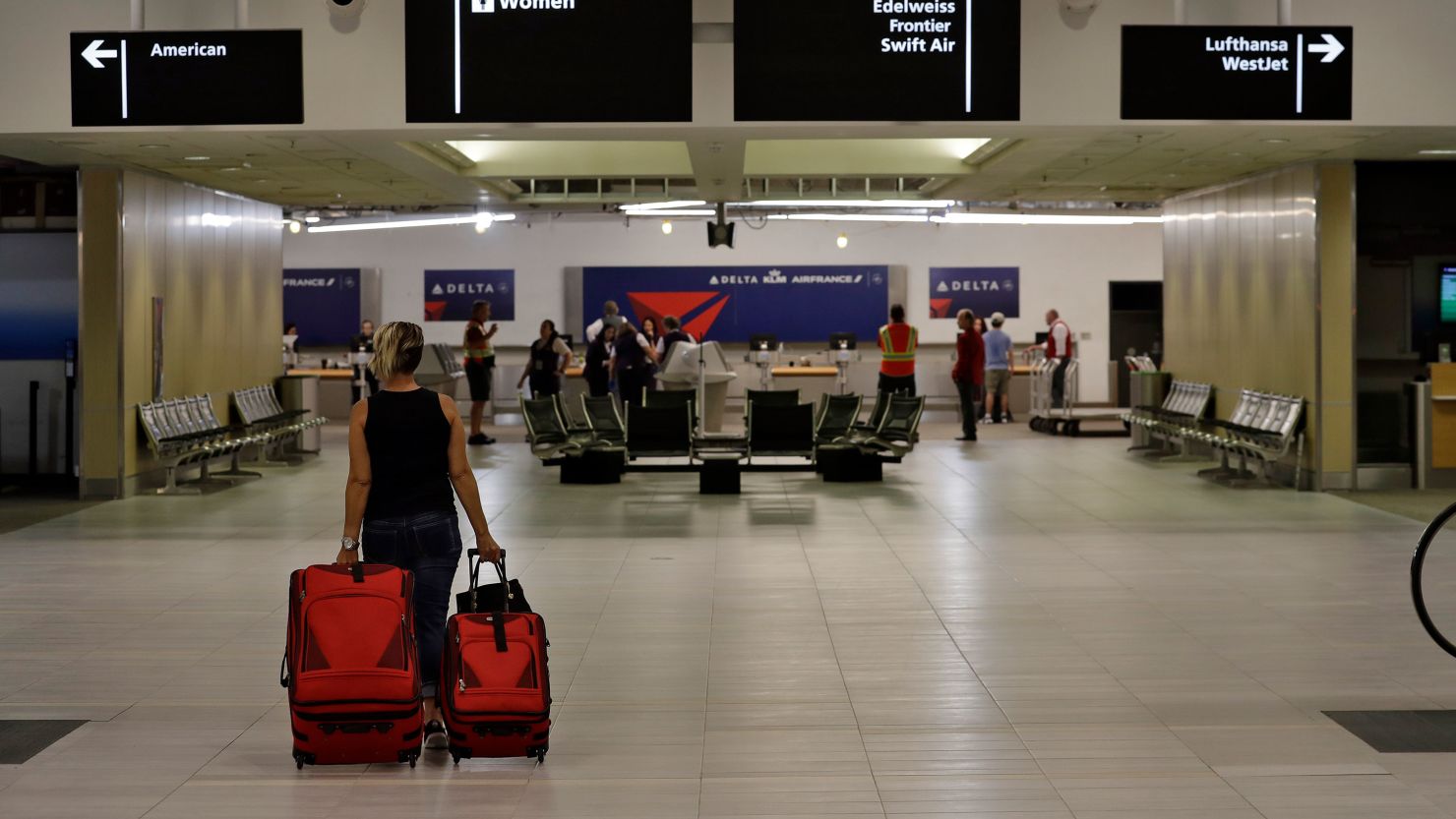A passenger carries her luggage through a nearly deserted terminal at the Tampa International Airport in April 2020.