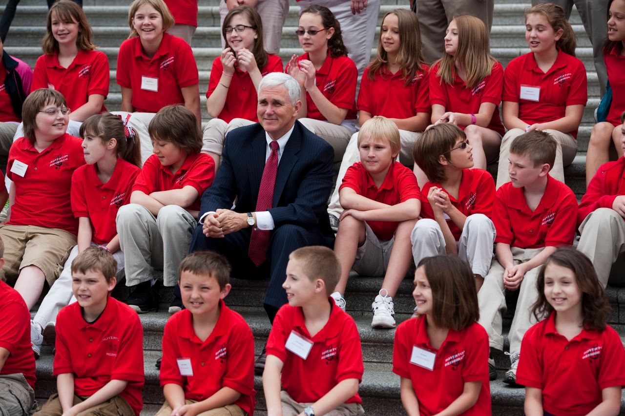 Pence sits with the Royerton Elementary School choir as it prepares to sing patriotic songs on the House steps in May 2011.