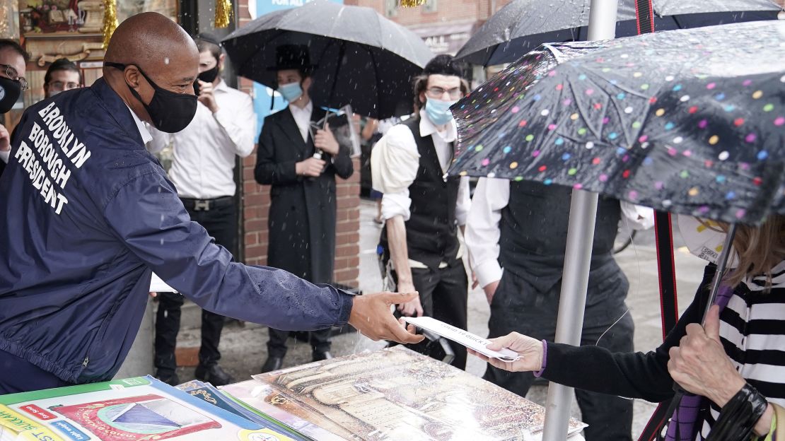 Brooklyn Borough President Eric Adams hands out a mask Tuesday.