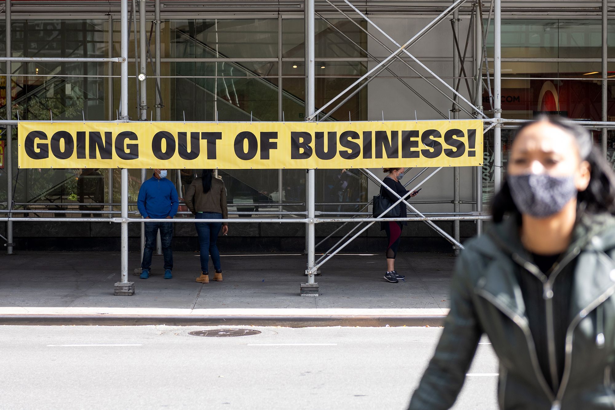 A woman wearing a mask walks by a "going out of business" sign as the city continues Phase 4 of re-opening following restrictions imposed to slow the spread of coronavirus on September 20, 2020 in New York City. The fourth phase allows outdoor arts and entertainment, sporting events without fans and media production. (Photo by Alexi Rosenfeld/Getty Images)