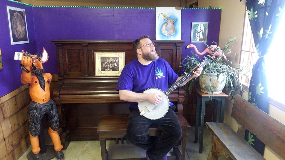 Thorin Thacker, owner of Canyon Cannabis, sings and picks at a banjo on April 11, 2018, at the Gates, Oregon, dispensary. Canyon Cannabis was destroyed by the Beachie Creek Fire on Sept. 8, 2020.