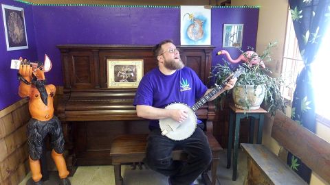 Thorin Thacker, owner of Canyon Cannabis, sings and picks at a banjo on April 11, 2018, at the Gates, Oregon, dispensary. Canyon Cannabis was destroyed by the Beachie Creek Fire on Sept. 8, 2020.