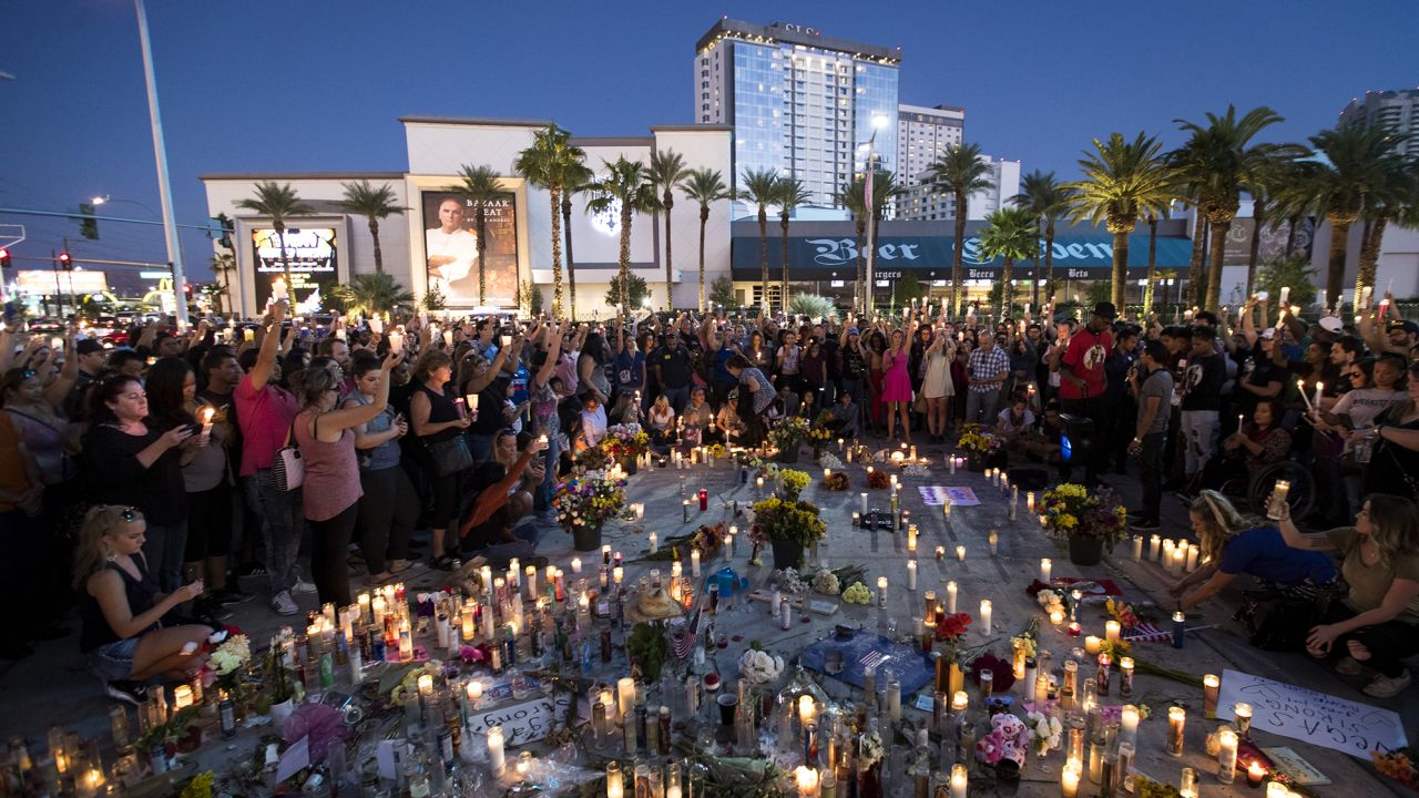 Mourners hold their candles in the air during a moment of silence during a vigil to mark one week since the mass shooting at the Route 91 Harvest country music festival.
