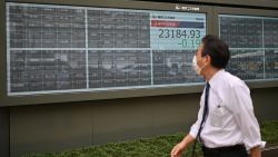 A man walks past an electronic board which normally displays stock prices at the Tokyo Stock Exchange but is empty after trading was halted due to a glitch in Tokyo on October 1, 2020. (Photo by CHARLY TRIBALLEAU / AFP) (Photo by CHARLY TRIBALLEAU/AFP via Getty Images)
