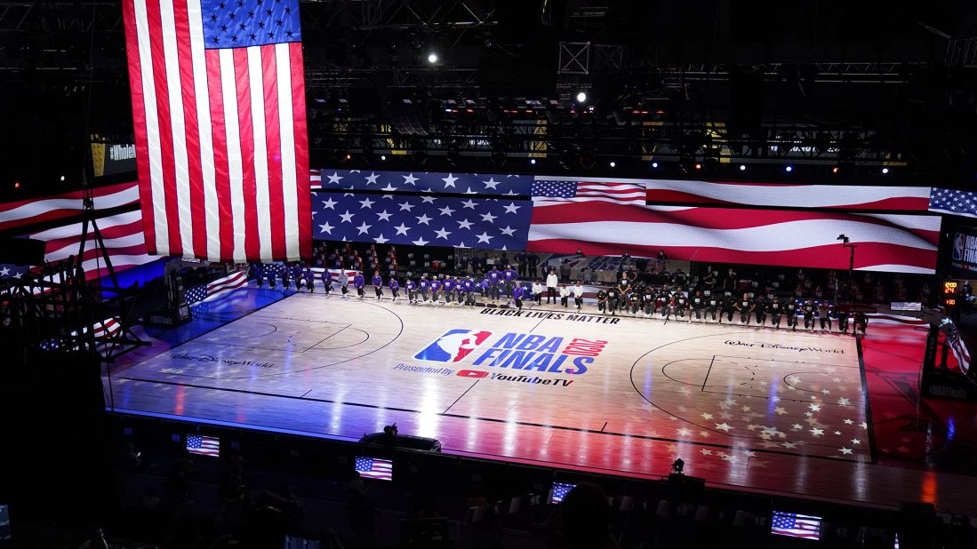 Members of the Los Angeles Lakers and the Miami Heat kneel during the National Anthem before Game 1 of the NBA Finals on Wednesday, September 30.