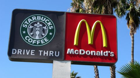 Signs for a McDonald's fast food restaurant and a Starbucks cafe are seen in Loma Linda, California in this February 28, 2010 file photo. McDonald's Corp reported on April 21, 2010, a better-than-expected quarterly profit as its coffee business boosted U.S. sales, and the hamburger chain said its global sales momentum was continuing into April. In the United States, where same-store sales rose 1.5 percent during the quarter and 4.2 percent in March, McDonald's results got a boost from its McCafe coffees and other beverages. The fast food chain encroached further into Starbucks Corp territory this quarter by introducing lower-priced frappes designed to compete with Frappuccinos. Picture taken February 28, 2010. REUTERS/Lisa Baertlein/Files   (UNITED STATES - Tags: BUSINESS FOOD)