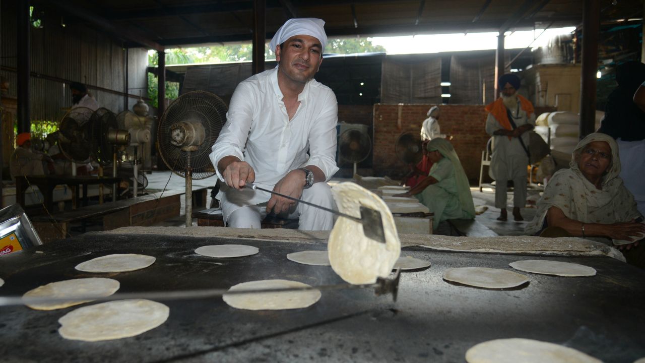 Vikas Khanna, MasterChef India host and executive chef of Junoon restaurant in New York, prepares a  chappati (flat bread) for a communal vegetarian meal at the Sikh Shrine Golden temple in Amritsar on September 7, 2016.
 