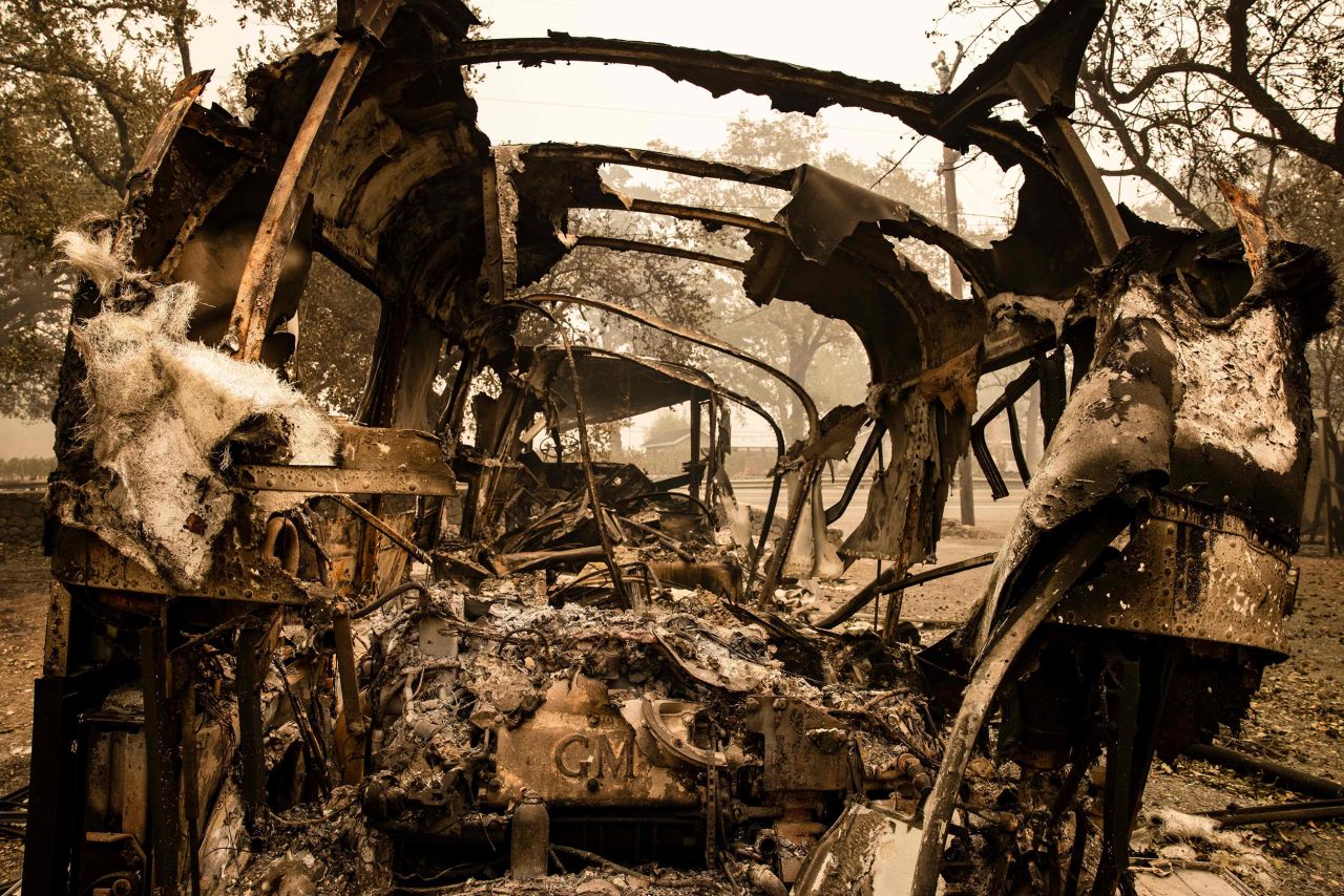Vehicles burned in the Glass Fire sit outside of a home that survived in Calistoga on September 30.