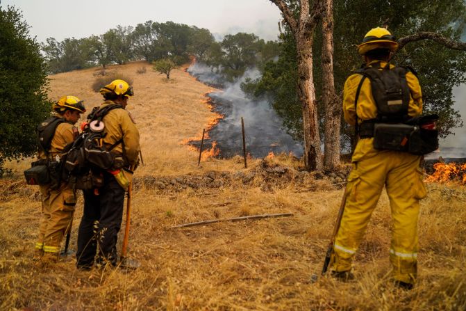 Firefighters watch the Glass Fire slowly creep across a clearing near Calistoga on September 29, 2020.